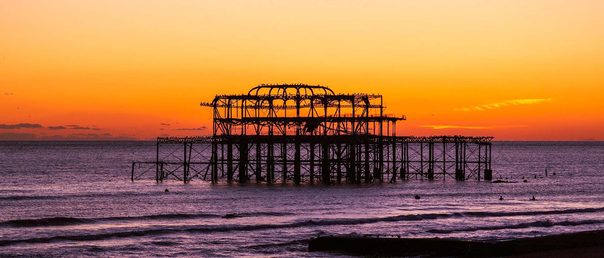 Brighton West Pier silhouetted against an orange sunset