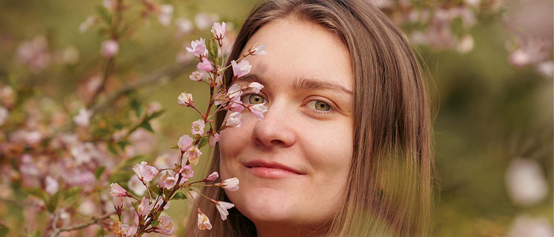 Outdoor portrait of Erin framed by blossom branches